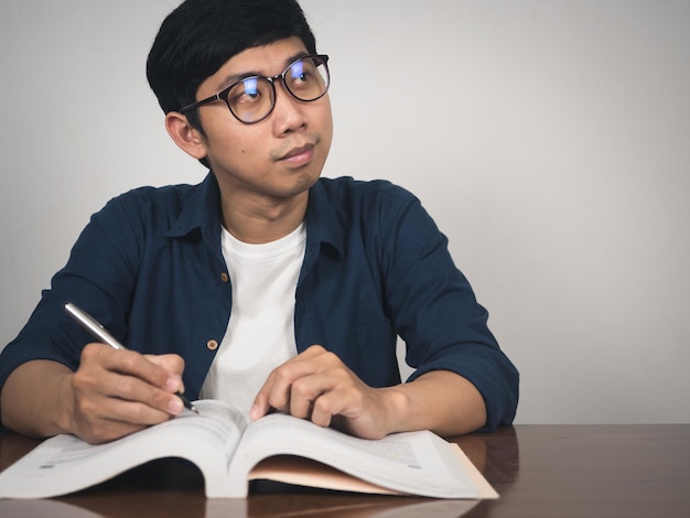 Asian man wear glasses studying with gentle smile