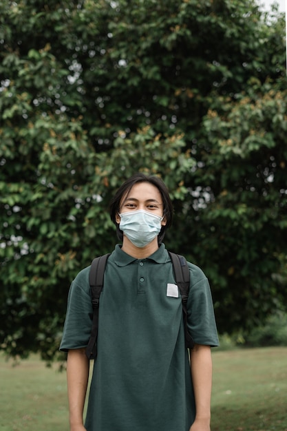 Asian man wearing a mask in a park to prevent the spread of covid 19