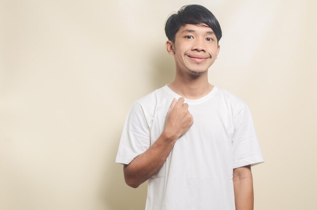 Asian man wearing white tshirt with happy expression and hands on chest on isolated background