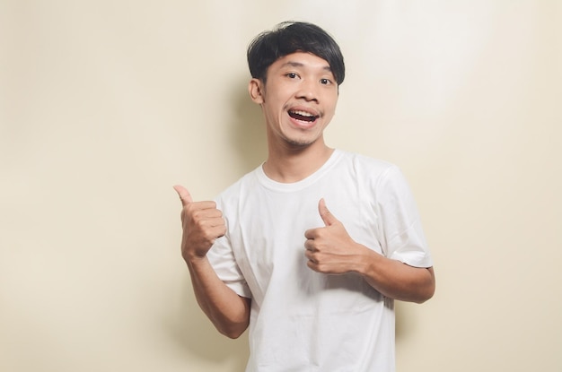 Asian man wearing white tshirt with happy gesture on isolated background