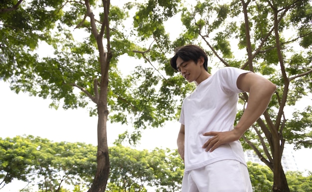 Asian man in white shirt happy in park Concept for health lifestyle in park