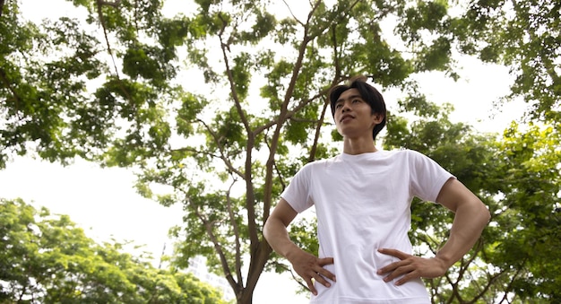 Asian man in white shirt happy in park Concept for health lifestyle in park