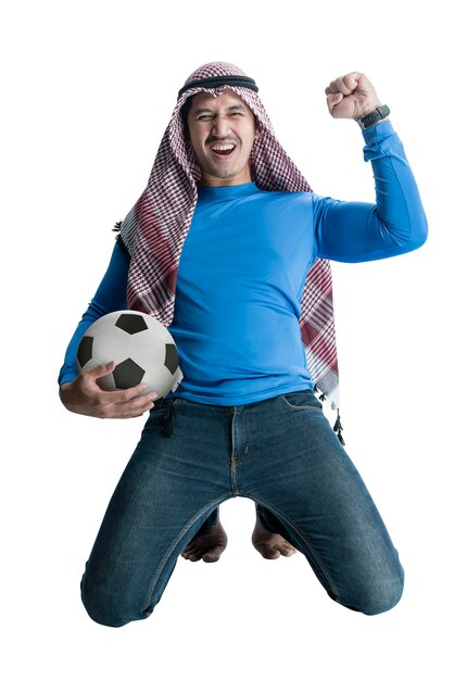 Asian man with keffiyeh holding the ball while celebrating victory with an excited expression