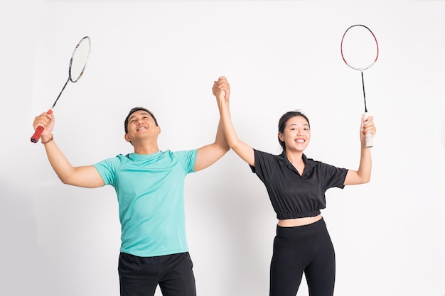 Asian man and woman holding racket with celebrating victory