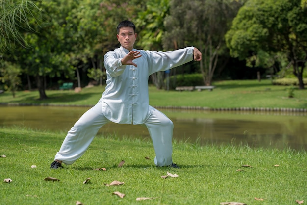 Asian man working out with Tai Chi in the morning at the park, Chinese martial arts