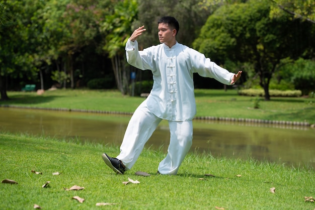 Asian man working out with Tai Chi in the morning at the park, Chinese martial arts