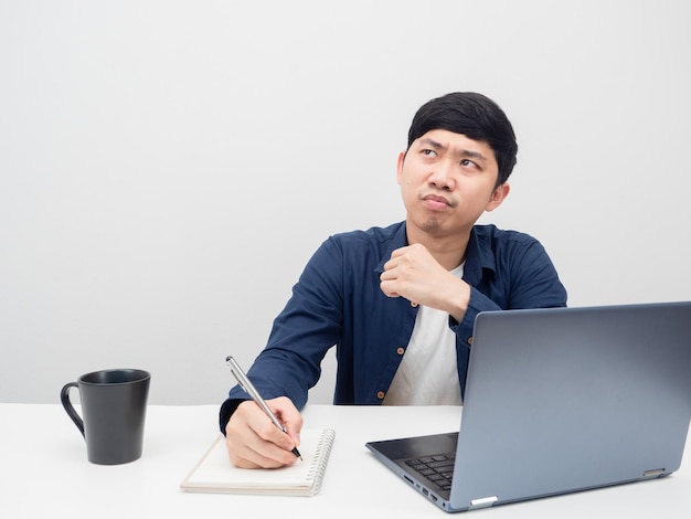 Asian man working at workplace feeling bored and looking at copy space