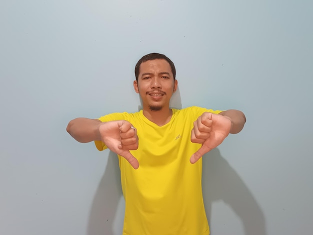 asian man yellow tshirt thumbs down