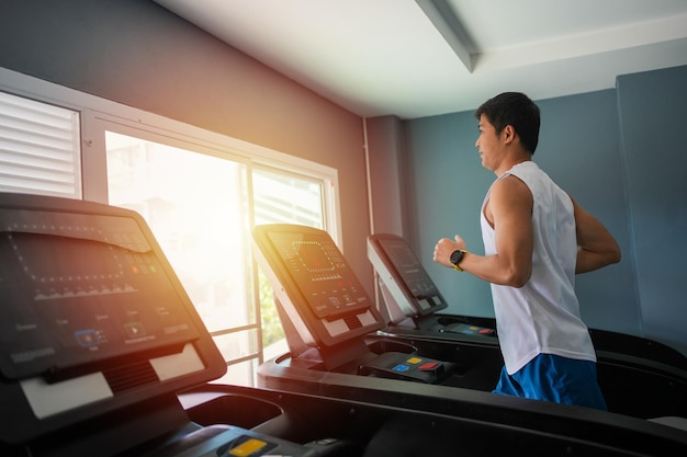 Asian men are happy jogging and running on a treadmill at gym