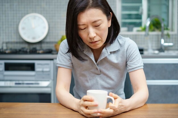 Asian middle aged woman with a tired look in the room