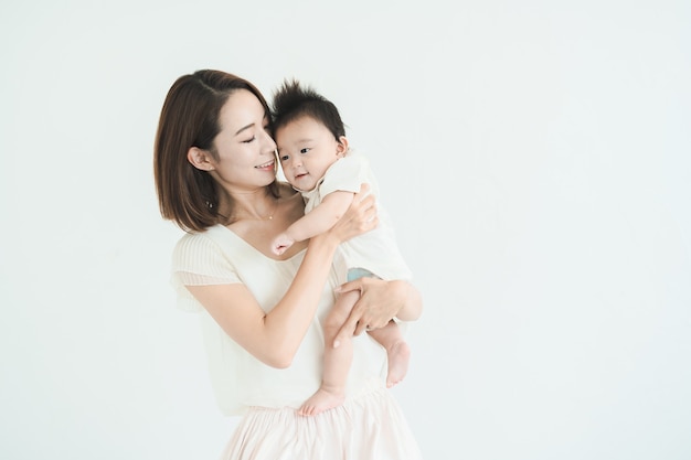 Asian mom holding a baby in the bright room