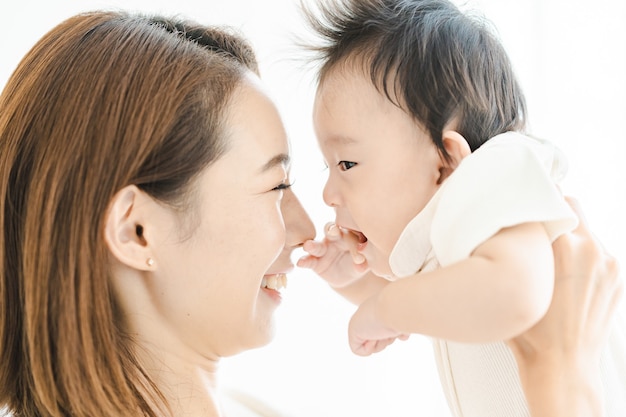 Asian mom holding a baby in the bright room