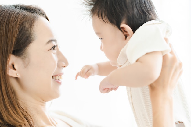 Asian mom holding a baby in the bright room