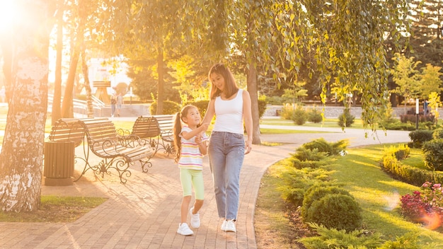 Asian mother and daughter walking in the park together