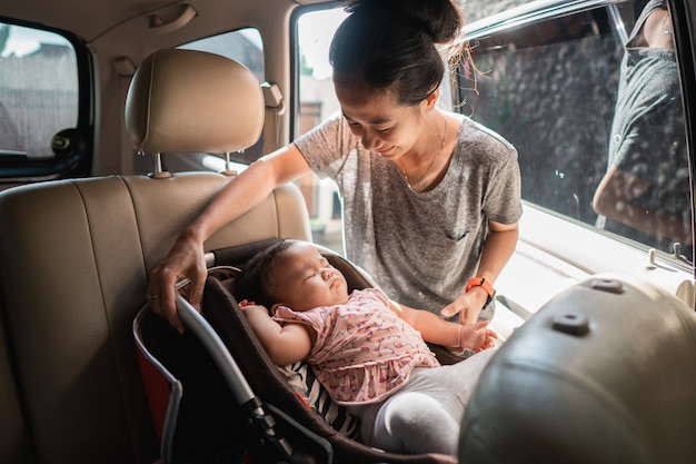 Asian mother fastening baby chair