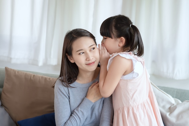 Asian mother feel happiness during playing her cute daughter with love and care at home