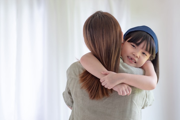 Asian mother make love with warm hug her cute daughter at home