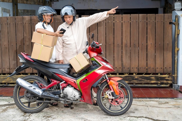 Asian Muslim family carrying a box on motorcycle ready for going mudik