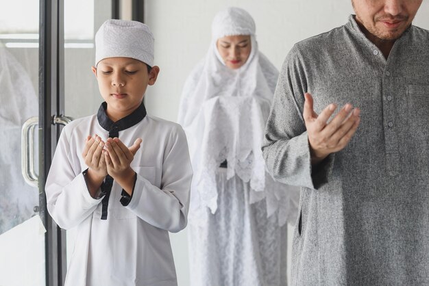 Photo asian muslim family praying dua together at mosque raising hands pray dua