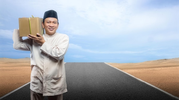 Asian Muslim man carrying box ready to mudik on the street