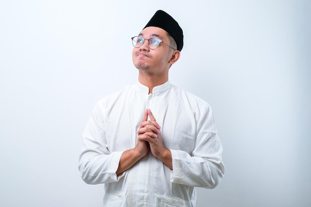 Asian muslim man doing thinking gestire looking for idea over white background