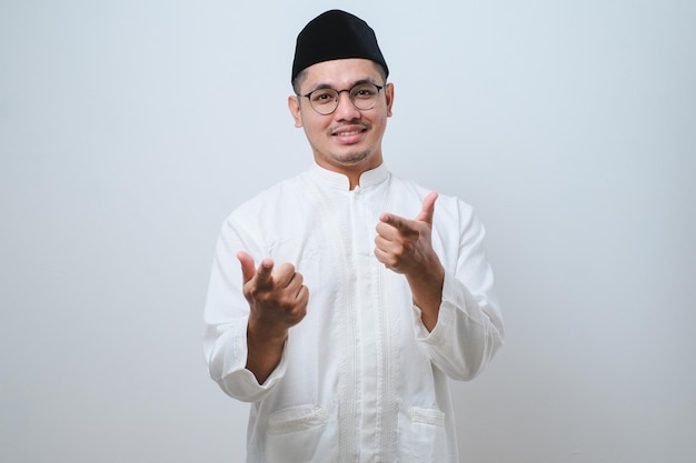 Asian muslim man pointing his both finger to camera over white background