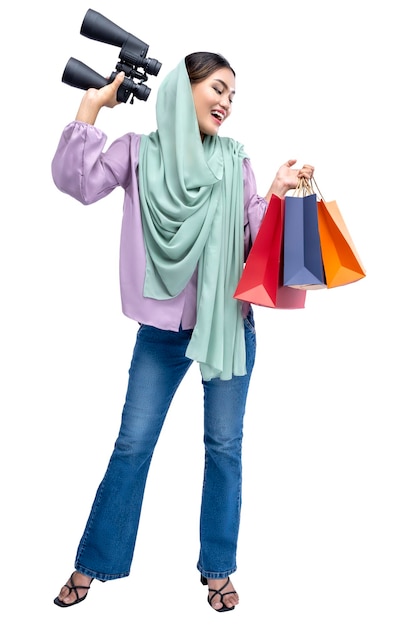 Asian Muslim woman in a headscarf holding binoculars and shopping bags