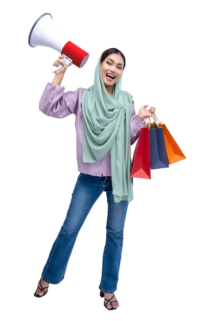 Asian Muslim woman in a headscarf holding a megaphone and shopping bags