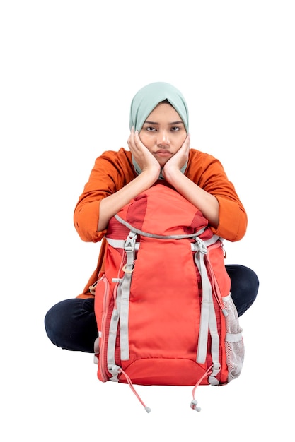 Asian Muslim woman in a headscarf sitting with a backpack