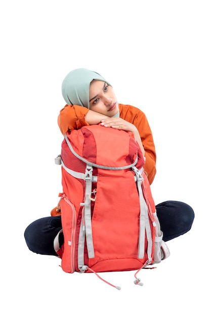 Asian Muslim woman in a headscarf sitting with a backpack