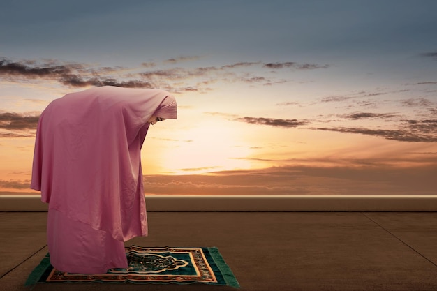 Asian Muslim woman in veil in praying position salat