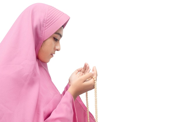 Asian Muslim woman in veil praying with prayer beads on her hands isolated over white background