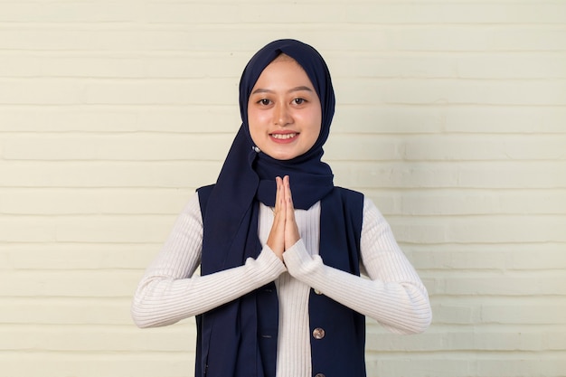 Asian Muslim woman welcoming guests gesture