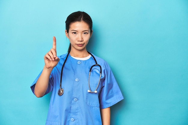 Asian nurse with stethoscope medical studio shot showing number one with finger