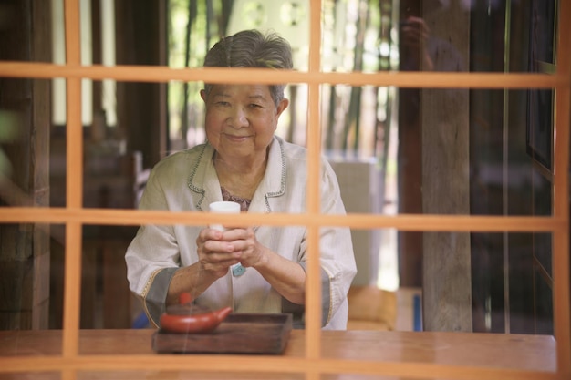 Asian old elderly female elder woman drinking tea senior leisure lifestyle