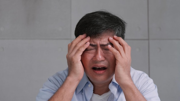 Asian old man with migraine headache Man feel stressed and worried about health problems