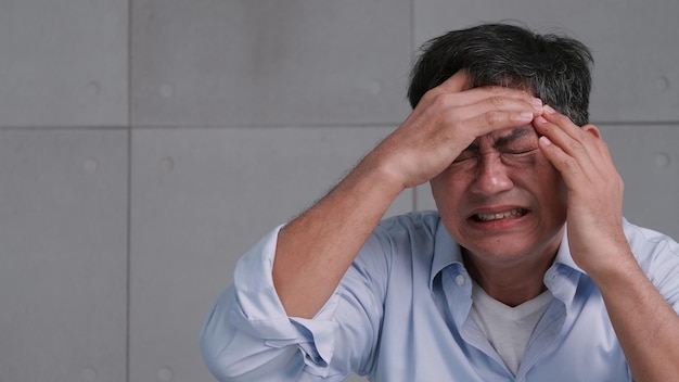 Asian old man with migraine headache Man feel stressed and worried about health problems