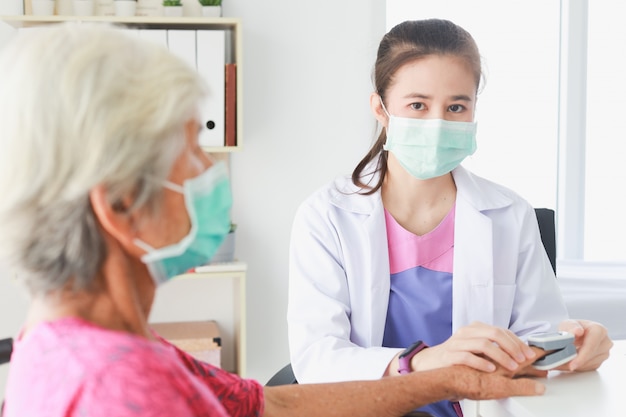 Asian Old Patient woman checking blood with Medical Doctor women in clinic office hospital