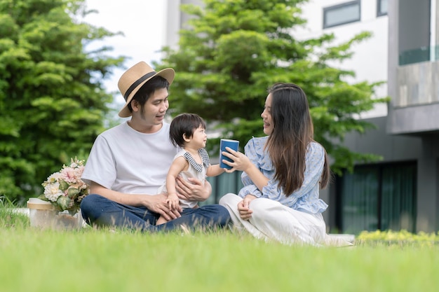 Asian Parents and a kid child playing in the garden at home. Family concept.