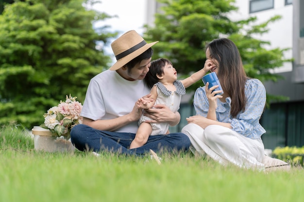 Asian Parents and a kid child playing in the garden at home. Family concept.