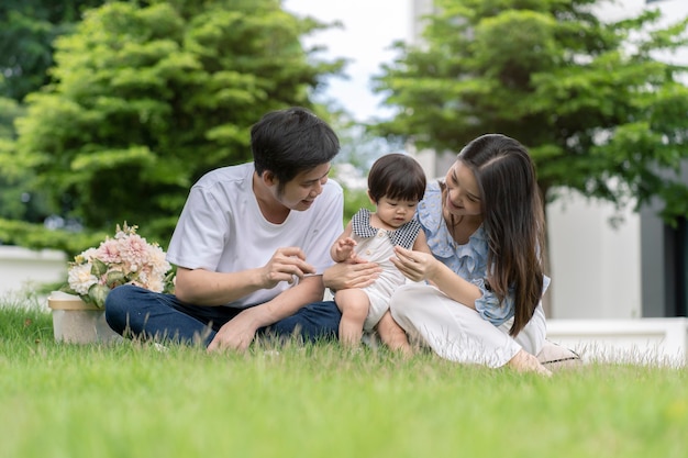 Asian Parents and a kid child playing in the garden at home. Family concept.