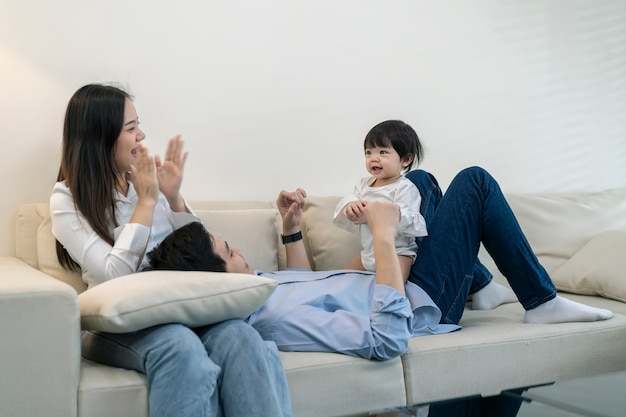 Asian Parents and a kid child playing at home. Family concept.