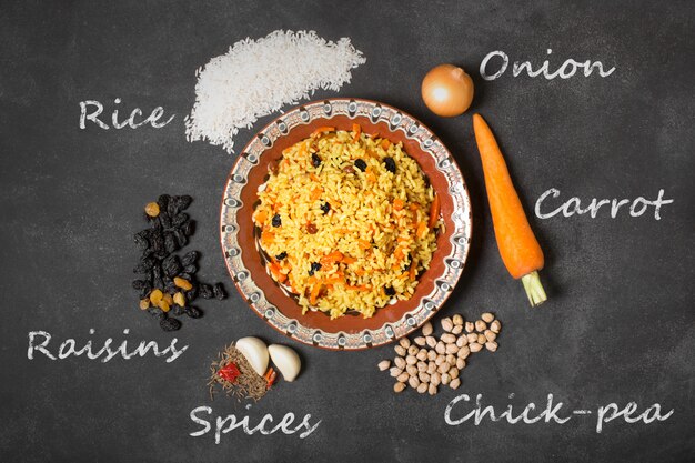 Photo asian pilaf on the black table. inscription of raw ingredients