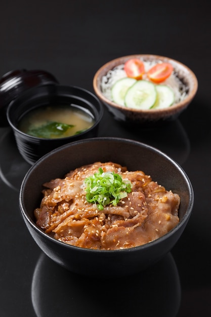 Asian pork with rice in ceramic bowls