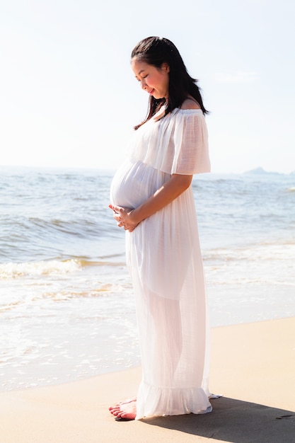 Asian pregnant women standing near the sea