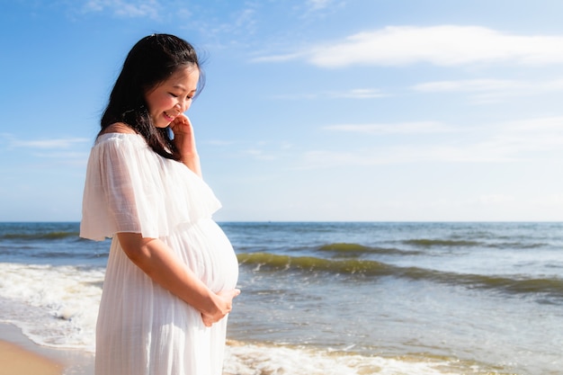 Asian pregnant women standing near the sea