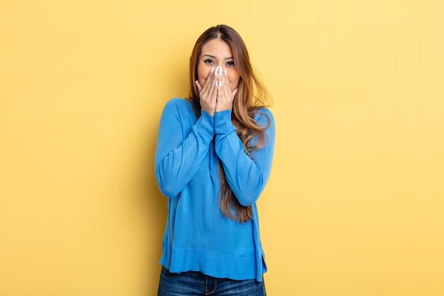 Asian pretty woman happy and excited, surprised and amazed covering mouth with hands, giggling with a cute expression