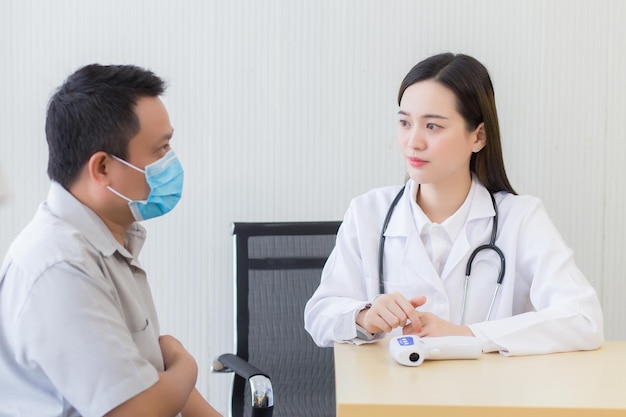 Asian Professional woman doctor talking with a man patient about his pain and symptom