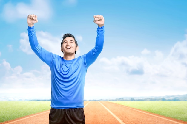 Asian runner man with excited expression after a run on the running track