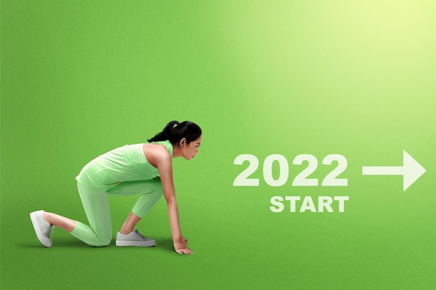 Asian runner woman ready to run with direction to start 2022. Happy New Year 2022